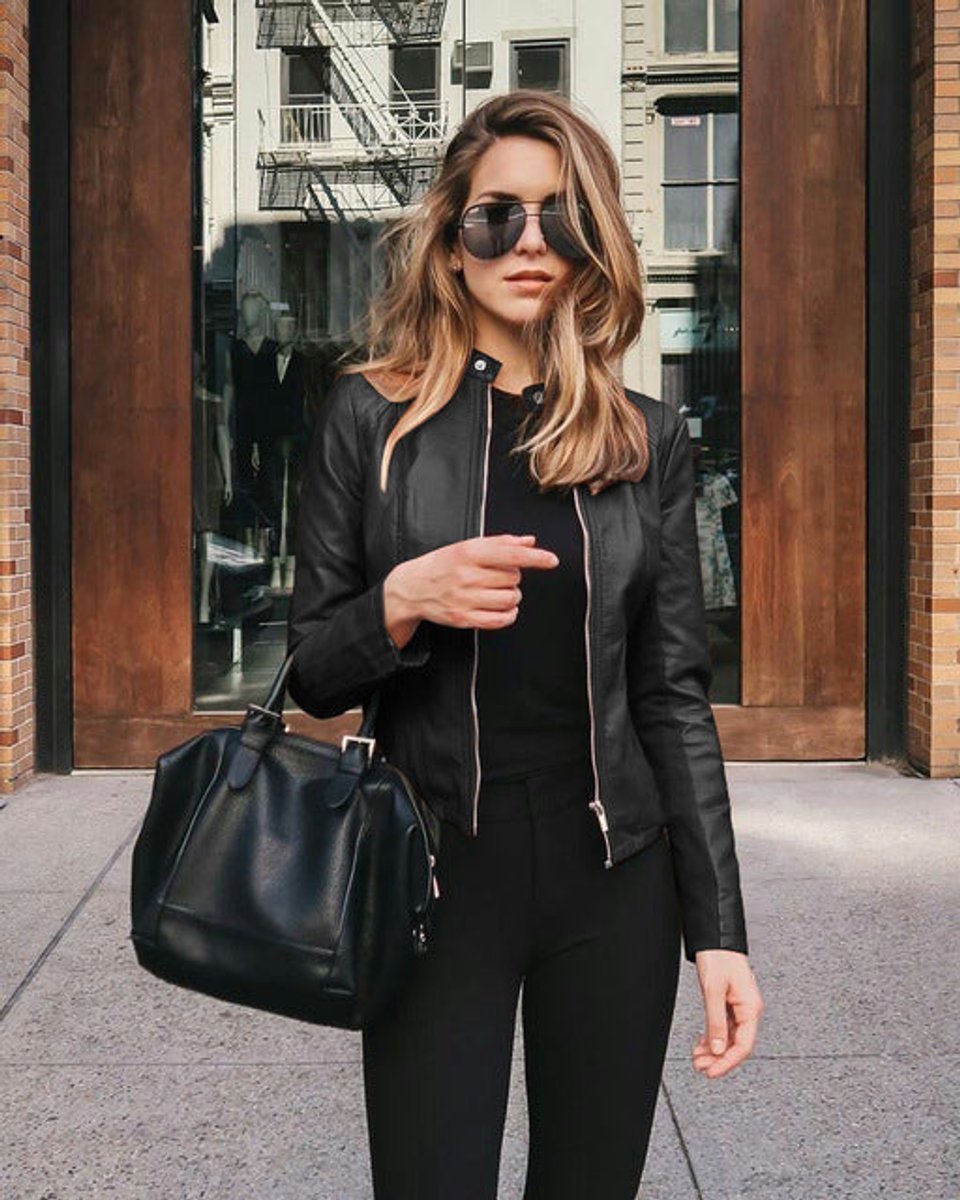 Woman wearing a black slim-fit biker jacket posing outdoors