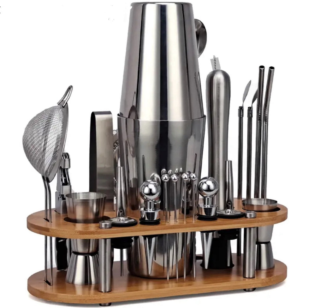 Stainless steel cocktail shaker and bartending accessories arranged neatly