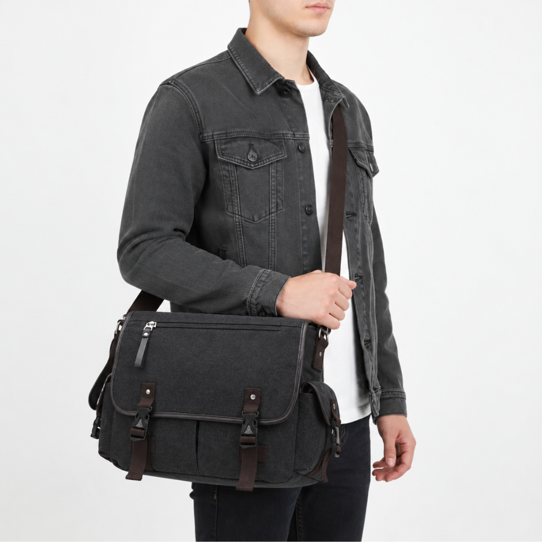 Studio shot of a man wearing a black canvas messenger bag with dual buckle straps