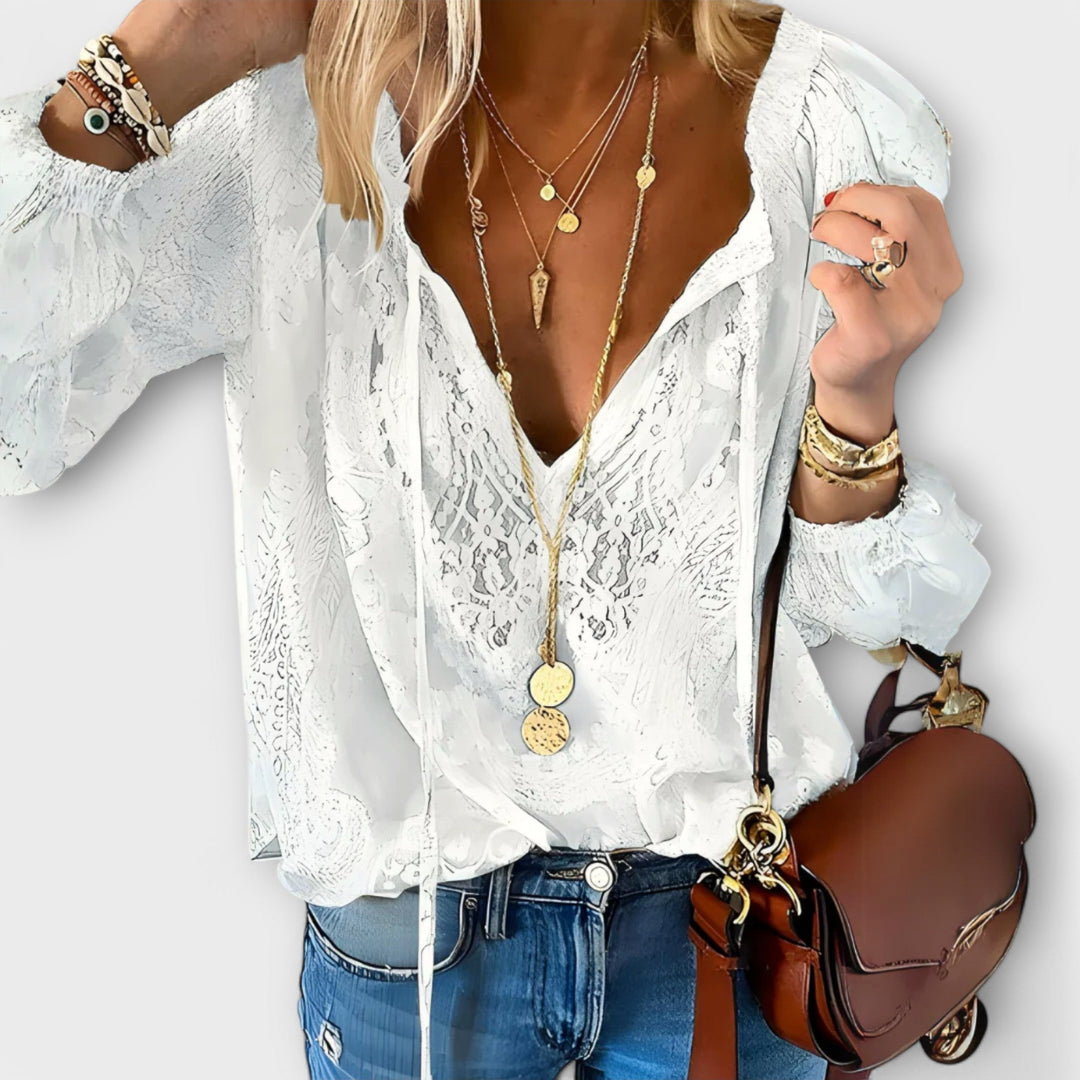Model wearing white lace overlay V-neck blouse with blue denim jeans