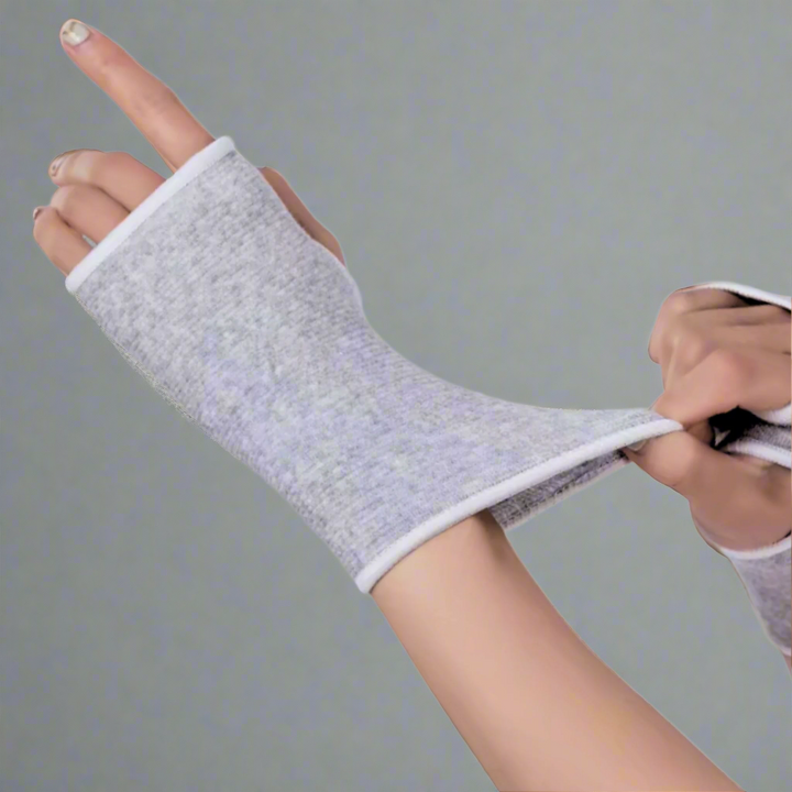 Flexible grey wrist compression sleeve being stretched