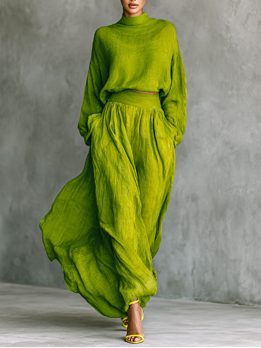 Woman modeling the vibrant green turtleneck top and flowing maxi skirt set against a grey wall