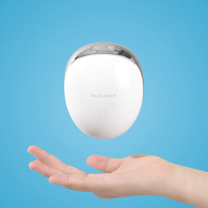 Handheld wireless electric scalp massager floating above a hand against a blue background