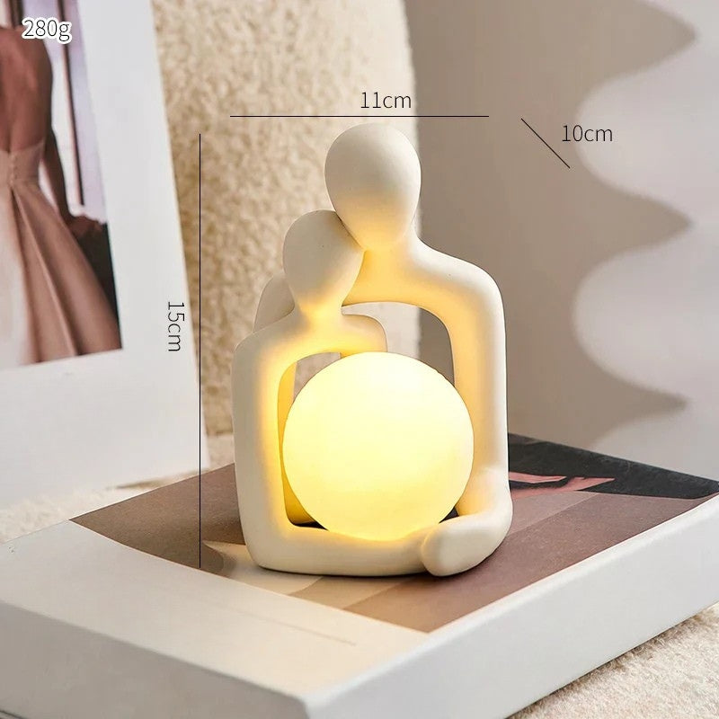 Ceramic couple mood light glowing softly on a wooden nightstand for cozy home decor