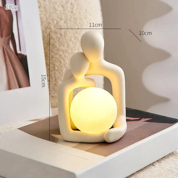 Ceramic couple mood light glowing softly on a wooden nightstand for cozy home decor