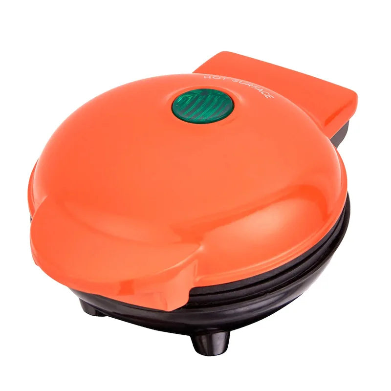 Bright orange mini waffle maker showing hot surface warning label