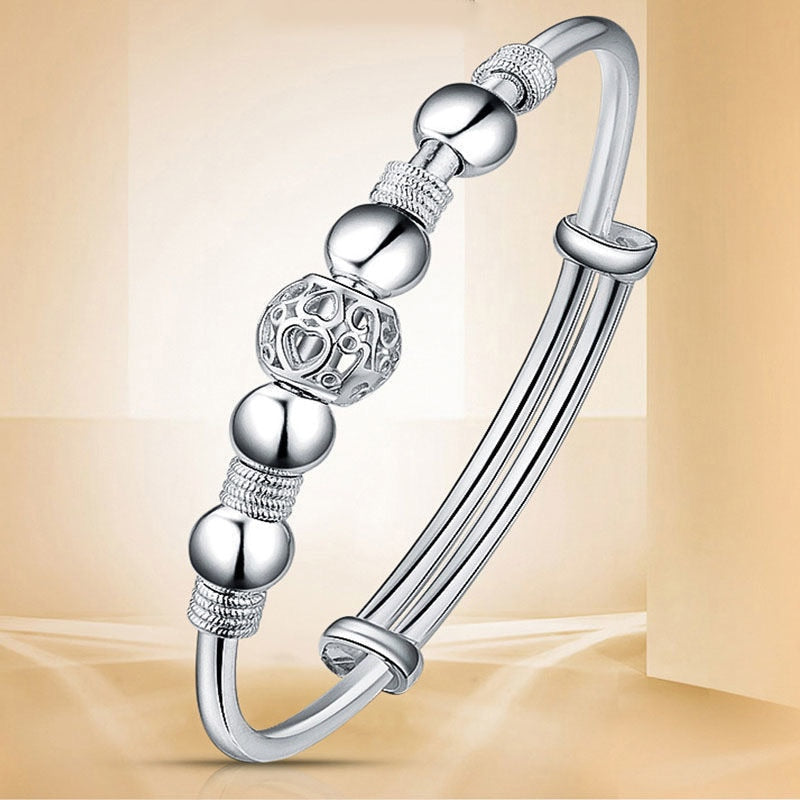 Studio product view of the adjustable silver charm bracelet showing the clasp design