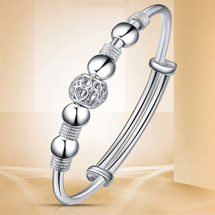 Studio product view of the adjustable silver charm bracelet showing the clasp design