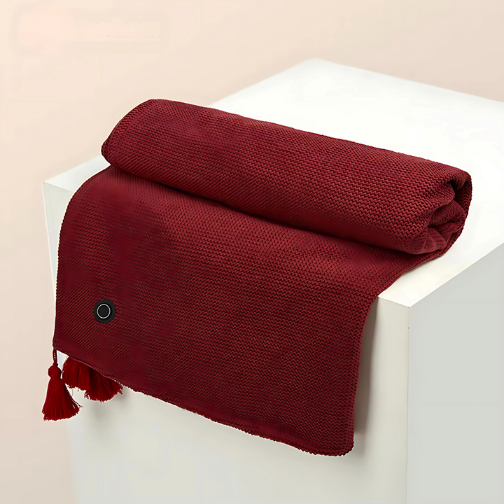 Red cordless USB heated shawl folded neatly with tassel detail on a display stand