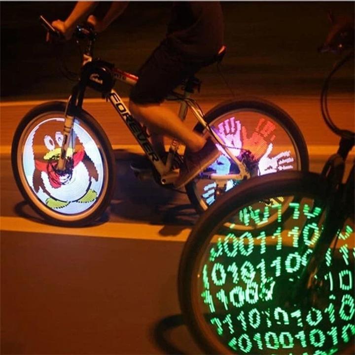 Cyclist riding a bicycle at night with illuminated 3D LED spoke lights