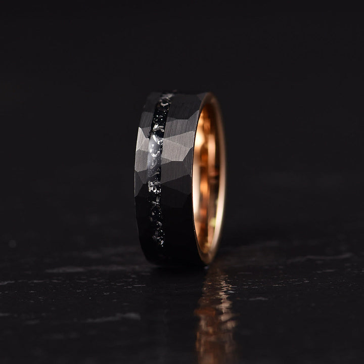 Detailed profile of men's modern black ring displaying rugged exterior texture