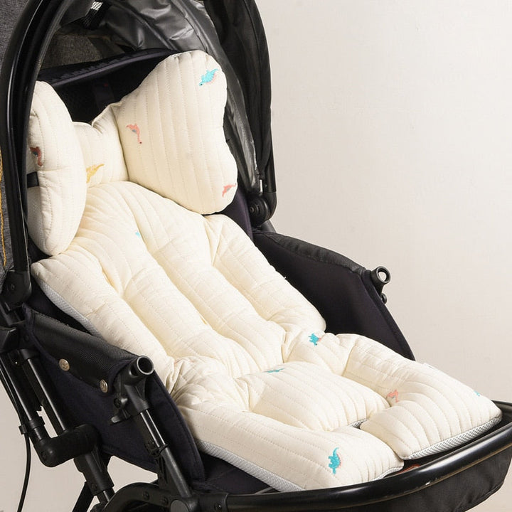 Toddler sitting comfortably on a patterned stroller cushion during a walk
