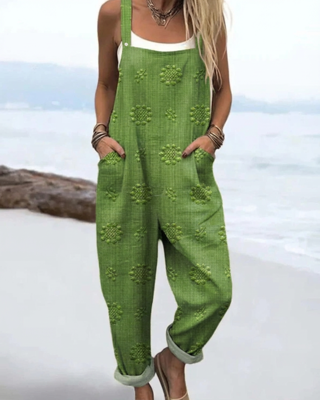 Model wearing green meadow glow floral jumpsuit by the water