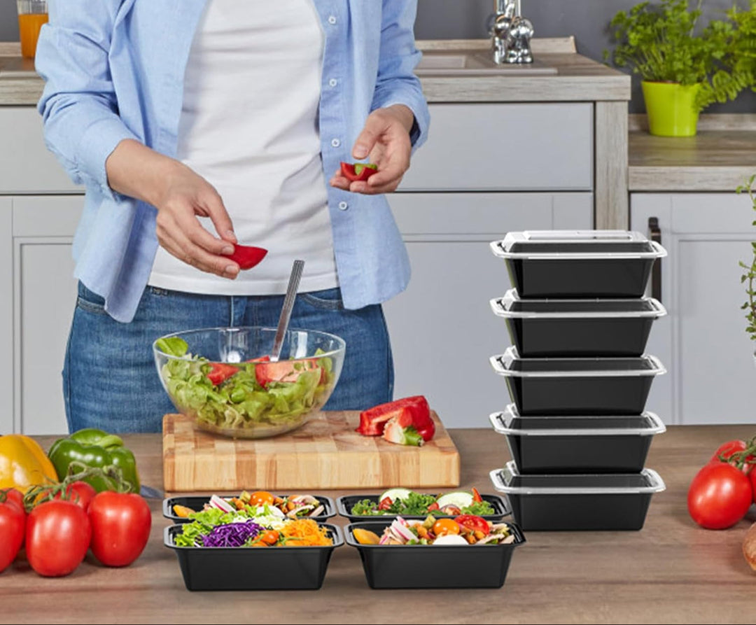 Woman preparing healthy meals with black food storage containers on kitchen counter