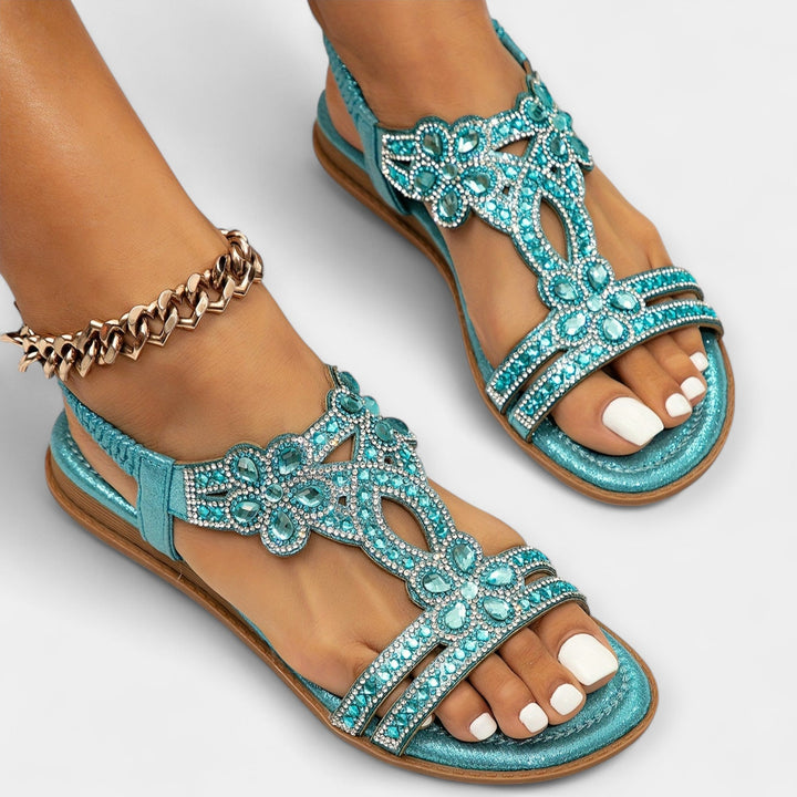 Close-up of woman wearing light blue crystal embellished flat sandals