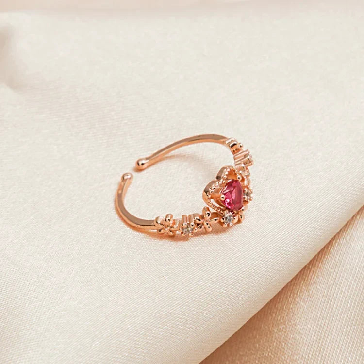 Scarlett Red Crystal Love Ring resting on satin fabric