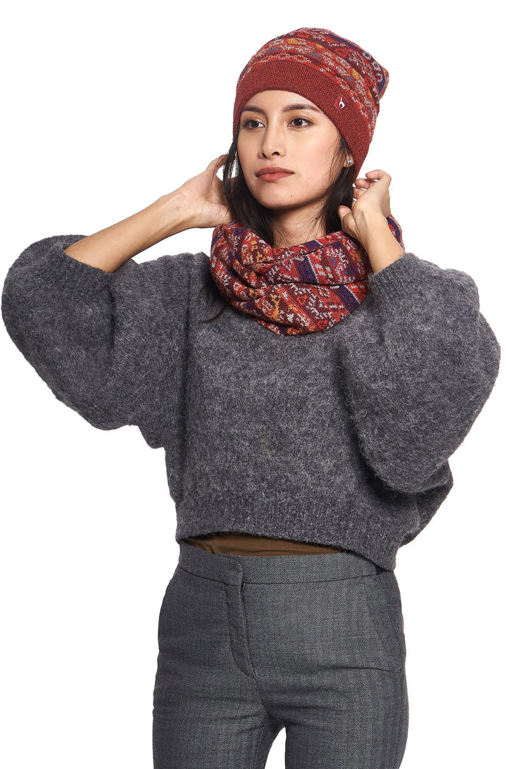Close-up front view of woman adjusting red knit winter beanie