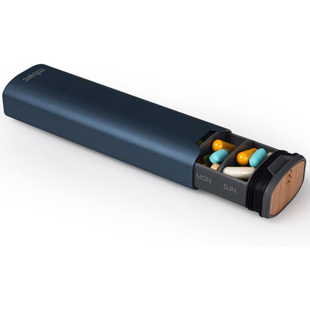 Close-up of the blue 7-day pill organiser with one end open showing capsules
