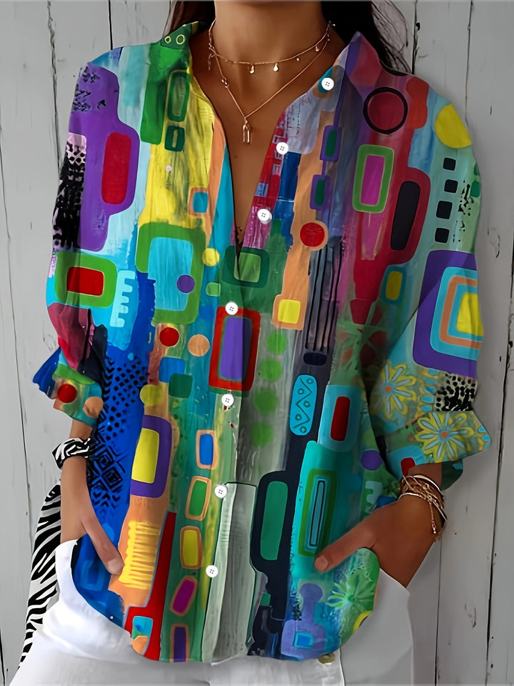 Woman wearing a colorful geometric print button-front blouse with rolled sleeves