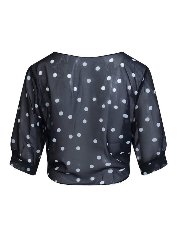 Side angle of the short sleeve polka dot top demonstrating the flattering drape and fit