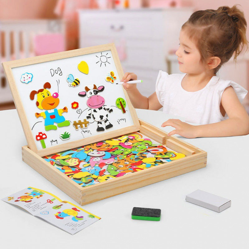 Young girl drawing with a marker on the magnetic whiteboard of the open wooden toy box
