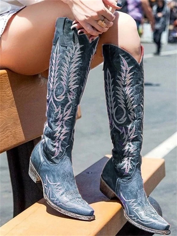Side profile of women's vintage embroidered knee-high cowboy boots with western stitching
