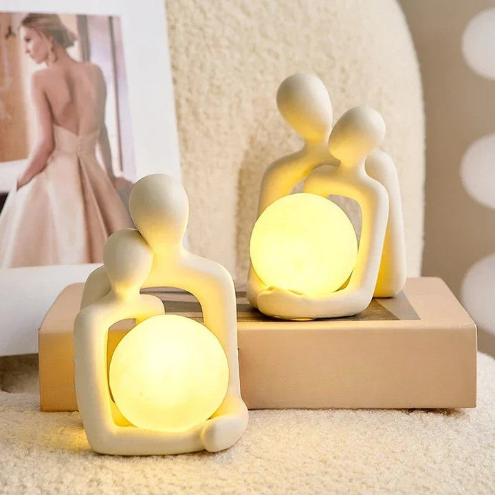 Close-up of the ceramic sculpture table lamp showing artistic couple design and texture
