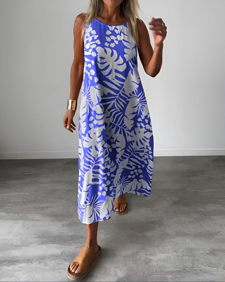 Woman wearing the Audrey elegant sleeveless dress in blue with botanical print