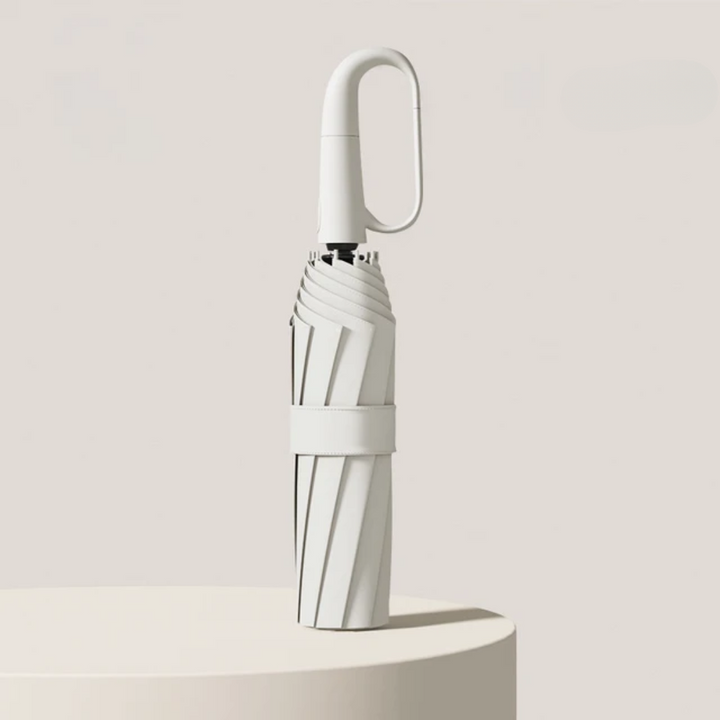 Compact travel umbrella folded down with wrist strap, ready for packing