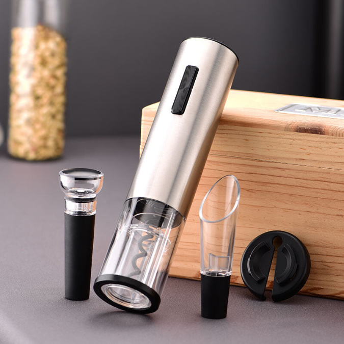 Electric wine opener standing next to foil cutter and pourer accessories