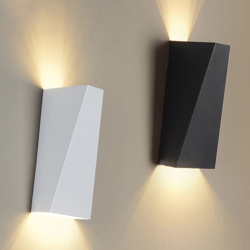 White and black modern wall sconce lighting fixtures mounted side by side