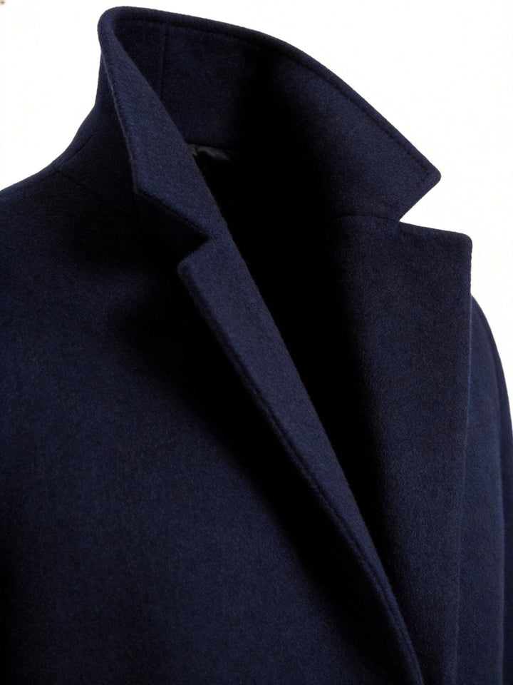Men's refined long trench coat in classic beige, front view showing double-breasted button closure.