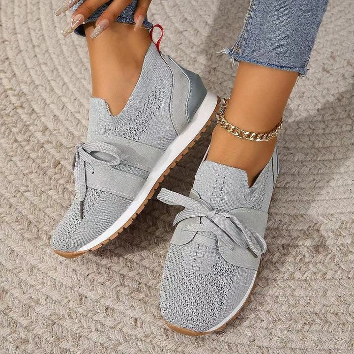 Grey women's orthopedic comfort heeled shoes shown on a textured rug