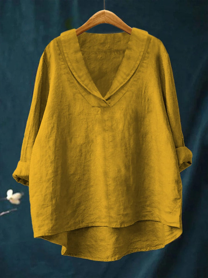 Yellow women's timeless blouse hanging on wooden hanger