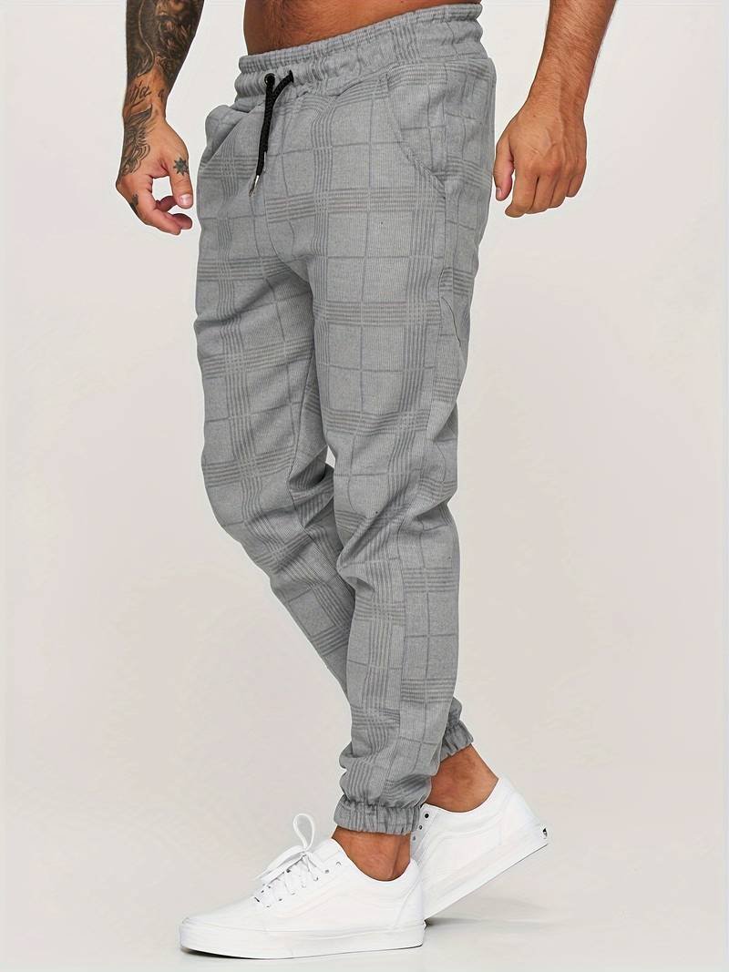Side profile of man wearing gray checked jogger pants