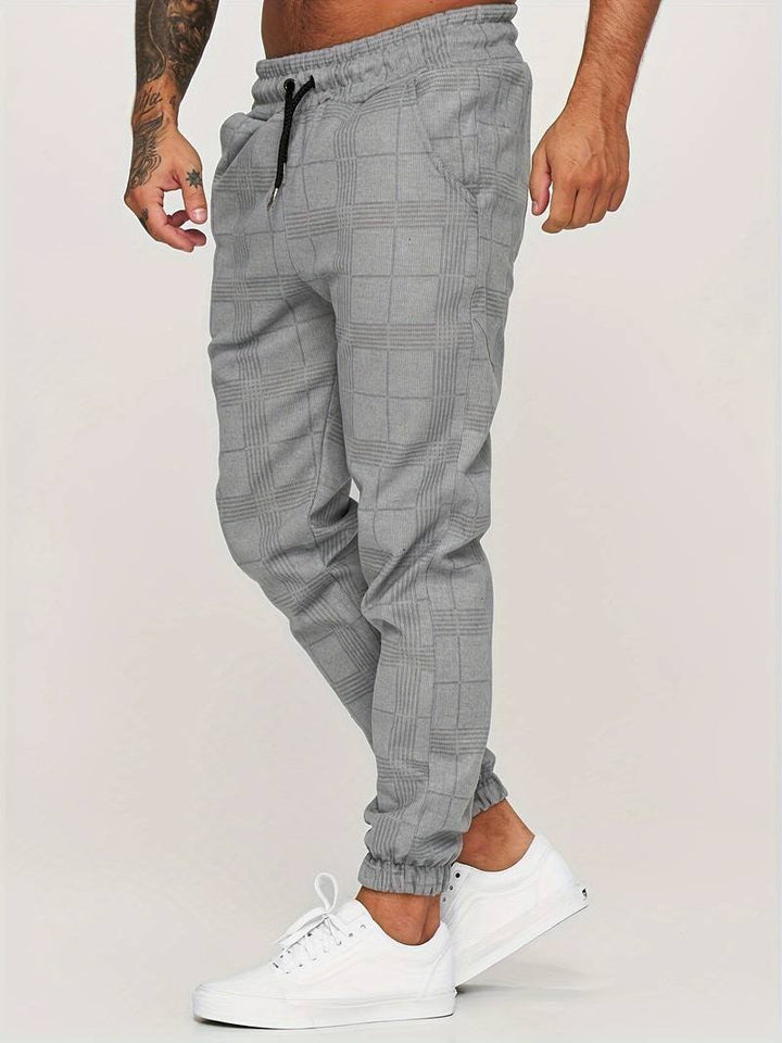 Side profile of man wearing gray checked jogger pants