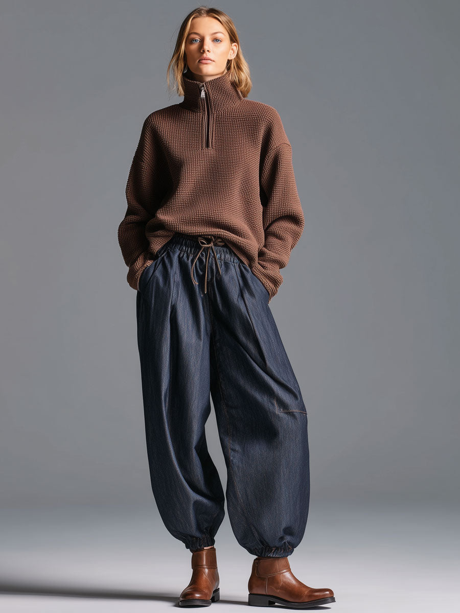 Full view of woman wearing retro navy blue lantern trousers and half-zip sweater