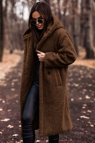 Woman wearing a rich brown hooded winter coat during cold autumn weather