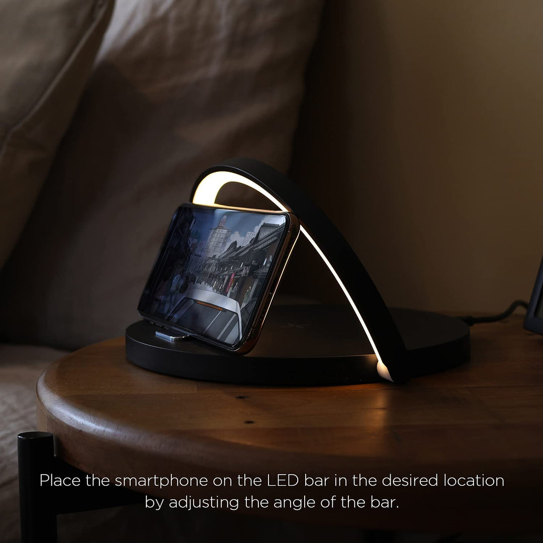 Adjustable LED lamp acting as a phone stand while illuminating a desk