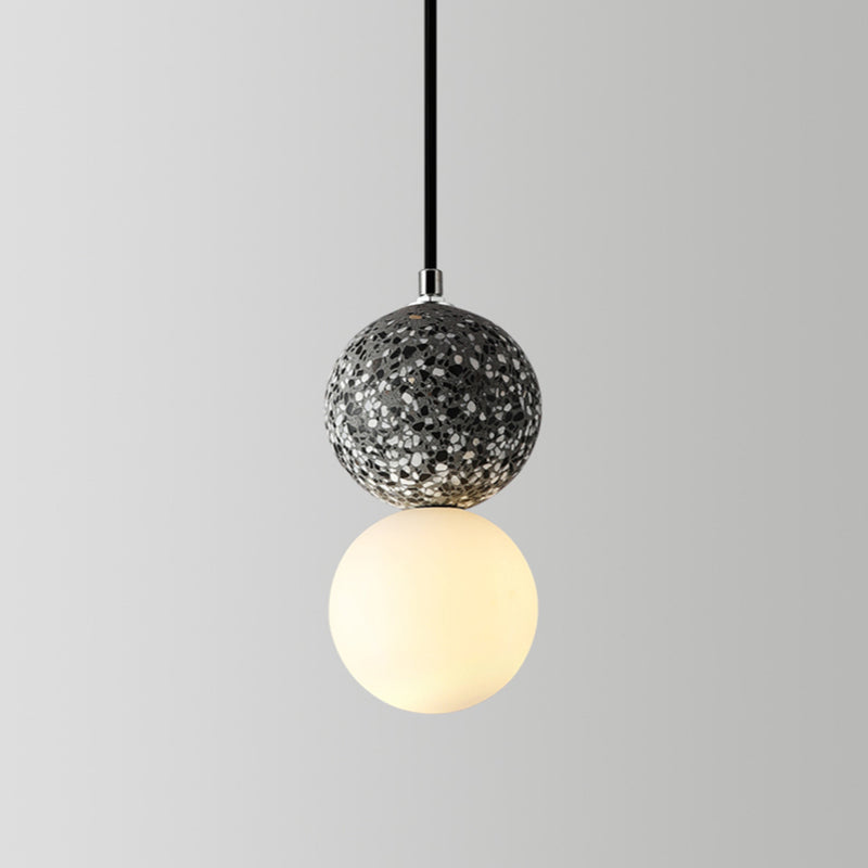 Single modern pendant light featuring a textured grey sphere and a glowing white orb underneath