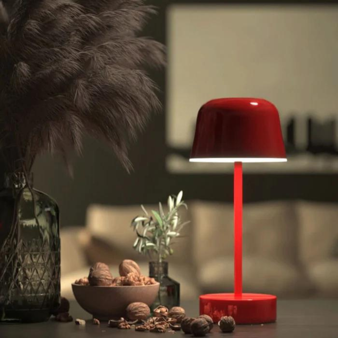 Red LED table lamp illuminating a cozy living room corner at night