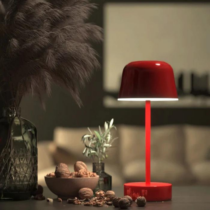 Red LED table lamp illuminating a cozy living room corner at night
