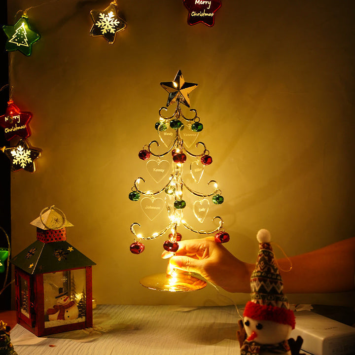 Hand holding the compact personalized Christmas tree on a festive tabletop setup