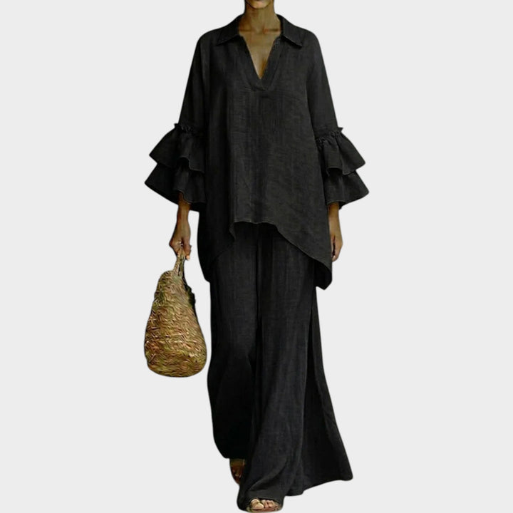 Model wearing black ruffle sleeve two piece matching set with wide-leg pants