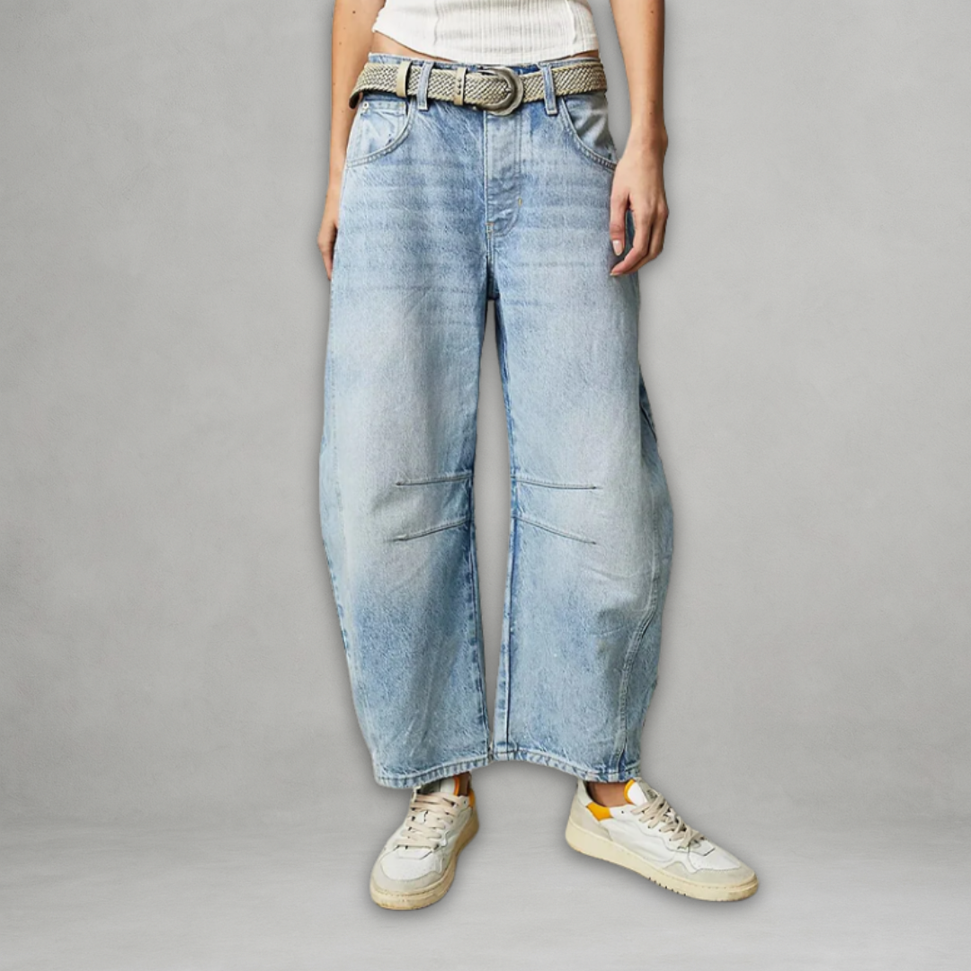 Woman showcasing light blue baggy jeans with a woven belt and sneakers