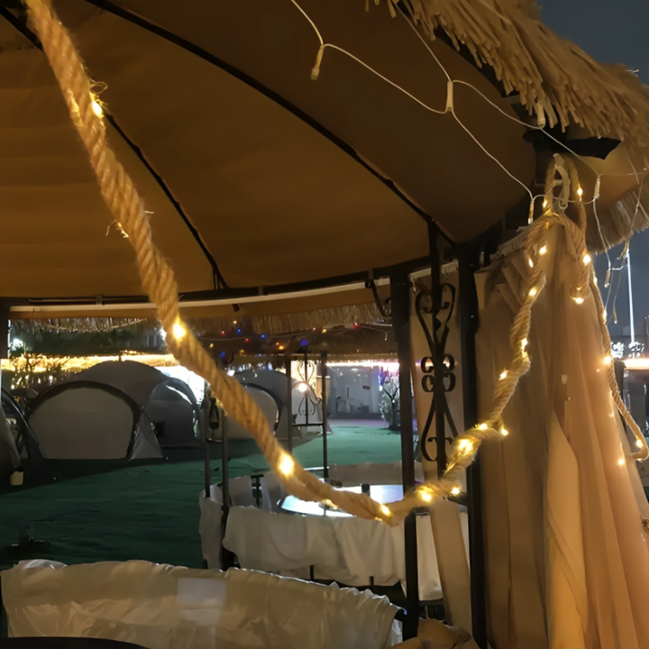 Retro outdoor rope lights glowing softly along a wooden backyard fence