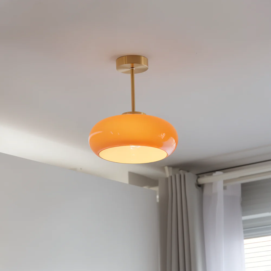 Orange glass ceiling lamp mounted on a white ceiling with a modern interior view
