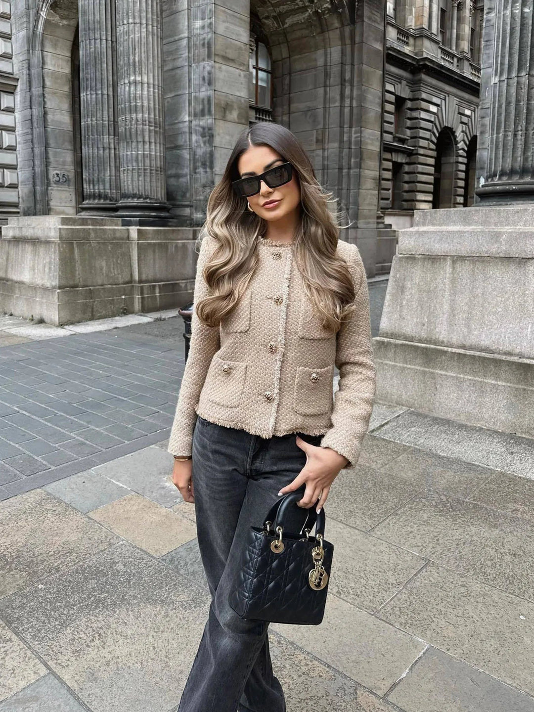 Woman wearing beige chic textured jacket outdoors with sunglasses