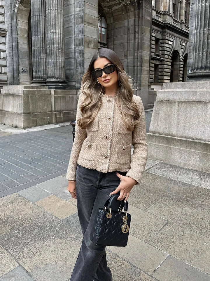 Woman wearing beige chic textured jacket outdoors with sunglasses