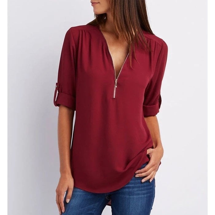 Woman wearing red zip V-neck 3/4 sleeve blouse with jeans